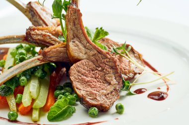 Sebze ve böğürtlen soslu ızgara kuzu eti. Beyaz arkaplanda gri.