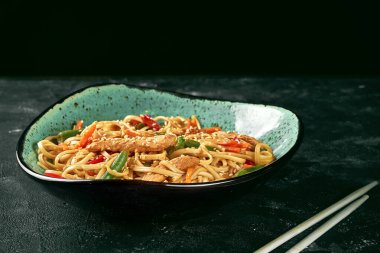 Tavuklu karabuğday udon noodle, yeşil tabakta kişniş sosu. Yaklaş, seçici odaklanma