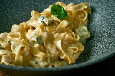 Gri tabakta peynirli kremalı fettucine makarna. İtalyan mutfağı