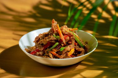 Biberli baharatlı Sichuan tavası eti, susam tohumu, havuç ve yeşil domates. Çin mutfağı.