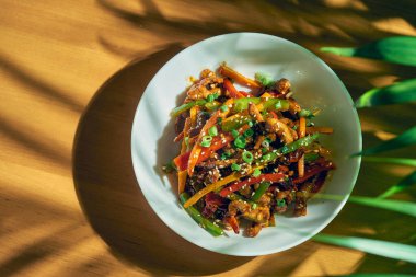 Sychang biberli tatlı ve ekşi soslu sebze ve biftek. Ahşap arka. Çin mutfağı.