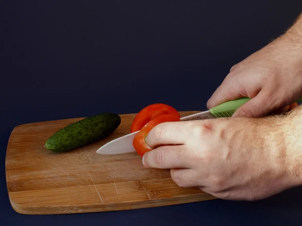 Les mains de l'homme coupé tomate rouge Images De Stock Libres De Droits