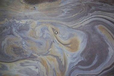 Asfalt üzerindeki yağ lekesi doku veya arka plan olarak görülür. Çevre kirliliği kavramı.