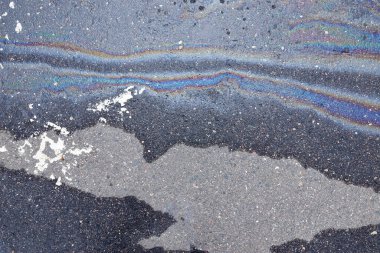 Otoparktaki renkli yağ lekeleri, kaldırım yolundaki benzin lekesinin rengi doku ya da arka plan olarak. Soyut gökkuşağı etkisi arka plan