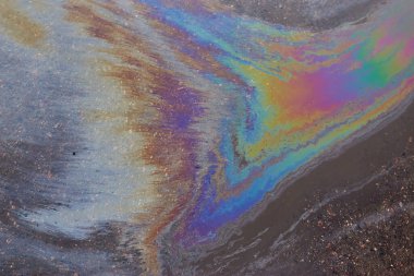 Otoparktaki renkli yağ lekeleri, kaldırım yolundaki benzin lekesinin rengi doku ya da arka plan olarak. Soyut gökkuşağı etkisi arka plan