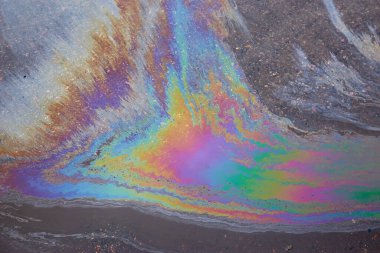 Otoparktaki renkli yağ lekeleri, kaldırım yolundaki benzin lekesinin rengi doku ya da arka plan olarak. Soyut gökkuşağı etkisi arka plan