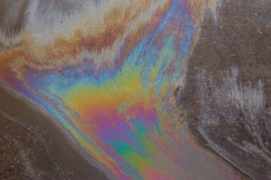 Güzel soyut arkaplan, doku, asfalttaki motor yağı lekeleri. Islak asfaltta renkli gaz lekesi..