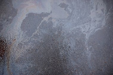 Asfalt yolundaki benzin lekesinin dokusu ya da arkaplanı olarak