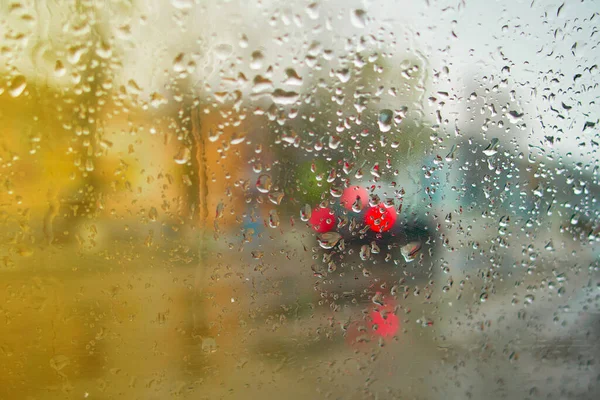 View from the inside of the car during the rain on the city street in defocus. Soft selective focus