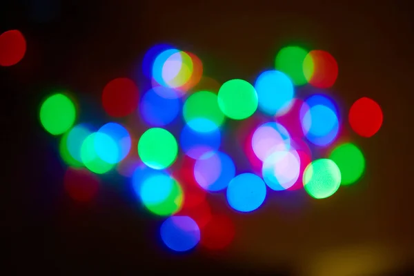 Colored lights Christmas garlands. Colorful abstract background. Blur and bokeh. Defocused bokeh lights