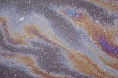 Güzel soyut arkaplan, doku, asfalttaki motor yağı lekeleri. Islak asfaltta renkli gaz lekesi.