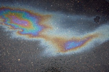 Güzel soyut arkaplan, doku, asfalttaki motor yağı lekeleri. Islak asfaltta renkli gaz lekesi..