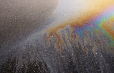 Güzel soyut arkaplan, doku, asfalttaki motor yağı lekeleri. Islak asfaltta renkli gaz lekesi..