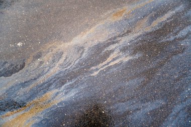 Güzel soyut arkaplan, doku, asfalttaki motor yağı lekeleri. Islak asfaltta renkli gaz lekesi..