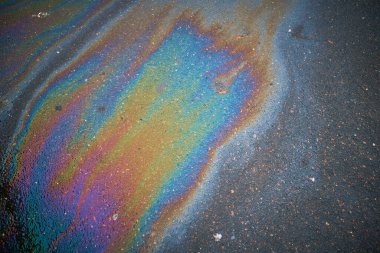 Güzel soyut renkli arka plan, doku: asfalttaki motor yağı lekeleri. Islak asfaltta renkli gaz lekesi..