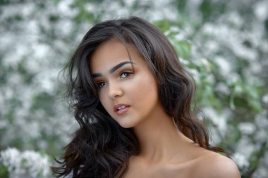 Bahçede, çiçek açan elma ağacının yakınındaki zarif ve zarif bir kızın portresi. Gençlik kavramı