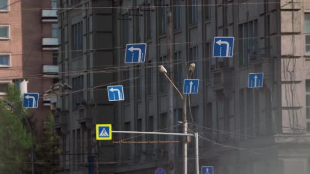 Útjelző táblák az épület hátterében. Forgalmi jelzések. — Stock videók