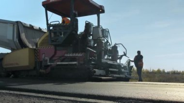 Novosibirsk Bölgesi, 15 Ağustos 2020 Yol işçileri asfalt kaldırımına asfalt karışımı yüklüyorlar..