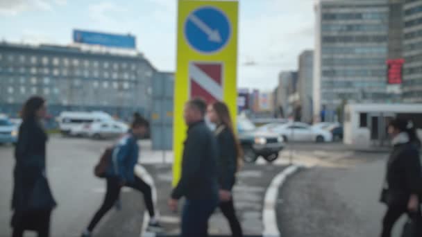 Lens desfocado. Trânsito, rua movimentada. Os pedestres atravessam a estrada com carros ao fundo durante a hora de ponta. Crowded crosswalk. Movimento lento. — Vídeo de Stock