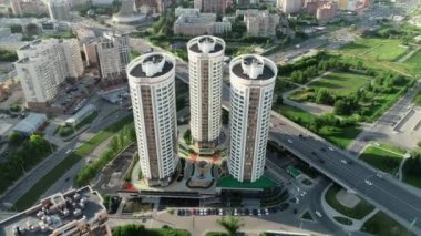 Şehrin arka planına karşı üç modern binanın etrafında helikopter uçurmak. Bir Avrupa şehrinde güneşli bir gün. Güzel manzara, şehir hayatı.