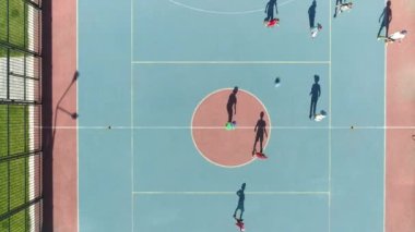 Futbol oynayan çocukların havadan tepeden aşağı görüntüsü. Futbol sahası çocuk parkı. Bahçede oynayan çocuklar futbol takımı. Yaz günlerinde çocuklar için dinamik oyunlar. Spor haberleri. Atletik.
