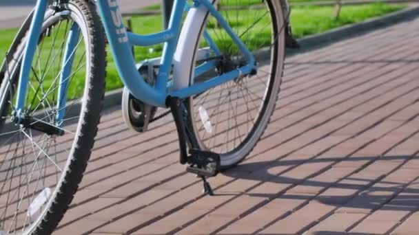 Novosibirsk, July, 15,.2019. Close-up of a bicycle. The girl gets on the bike and drives off. Summer sunny day. Bicycle wheels, pedals. Sport shoes. — Stock Video