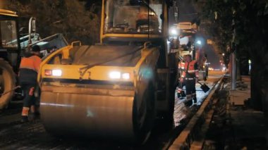 Novosibirsk bölgesi, 7 Eylül 2019. Yol silindiri, asfalt kaldırım. Gece bir şehir yolunun tamiri. İş yerindekiler.