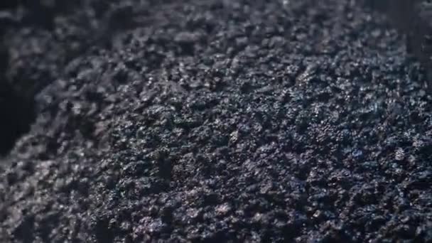 Gros plan du mélange d'asphalte frais. Un paveur d'asphalte pose un mélange d'asphalte sur la route. Réparation de routes la nuit, construction de nouvelles routes. — Video