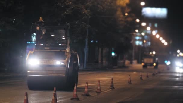 Gebiet Nowosibirsk, 7. September 2019. Straßenwalze legt Asphalt in der Stadt. Straßenreparaturen in der Nacht. Straßensperren, Kegel. — Stockvideo