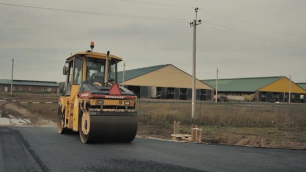 Novosibirsk região, 3 de setembro de 2019. O rolo de estrada está colocando asfalto. Reparação, construção de estradas. — Vídeo de Stock