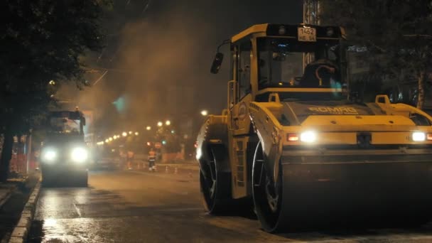 Gebiet Nowosibirsk, 7. September 2019. Zwei Straßenwalzen verdichten den Asphalt in der Stadt. Dampf aus heißem Asphalt. Straßenreparatur. — Stockvideo