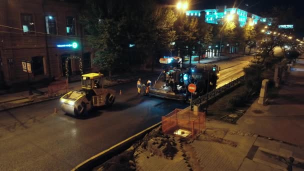 Novosibirsk region, 2019 년 9 월 7 일. 공중에서 본 모습. 두 대의 도로 공사가 아스팔트를 깔고 있습니다. 아스팔트 주조기가 작동하고 있습니다. 도시 의도로 보수 공사. — 비디오