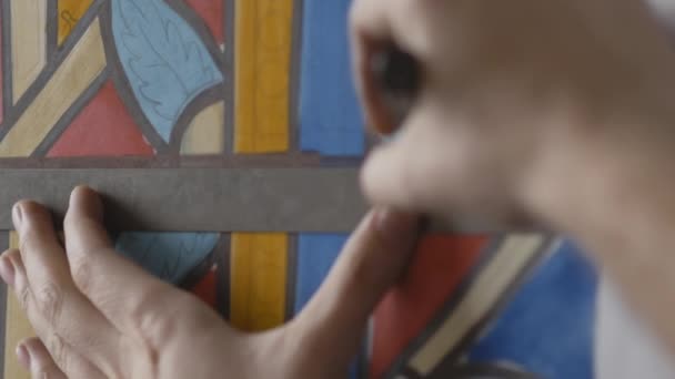 Close-up das mãos dos artistas. O artista desenha uma vassoura em um esboço de uma janela de vidro manchado. Desenhar a trança do vitral. — Vídeo de Stock