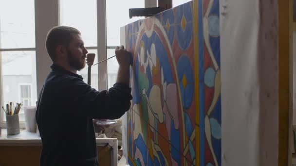 A művész egy festett üvegablak vázlatán dolgozik. Művészeti műhely. — Stock videók