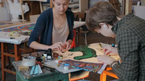 Novoszibirszk régió, 2020. szeptember 18. Két művész dolgozik egy festett üvegablak létrehozásán. Művészeti műhely, kézzel készített. — Stock videók