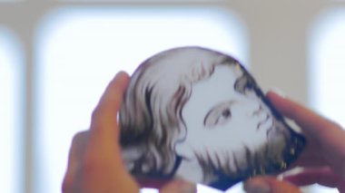 Sanatçı vitrinin ışık kısmına bakar. El yapımı, boyalı cam bir pencere oluşturma.