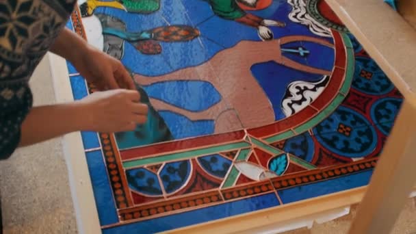 A művész összegyűjti a festett üvegmozaik részleteit. Kézzel készített. Foltos üvegműhely. — Stock videók
