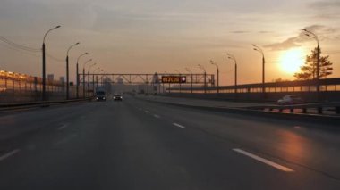 Arabalar yol boyunca gider. Şehirdeki otoban. Gün batımında otoyol.