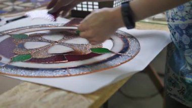 İki sanatçı vitraylı camlardan bir kompozisyon oluşturuyor. Vitrindeki parçaları birleştiriyorum. İki kadının elleri. El yapımı el yapımı. Tiffany boyalı cam. Resmin ayrıntıları. 