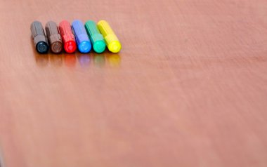 Ahşap bir masa üzerinde birçok çok renkli Keçeli Kalemler.