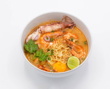 Tom Yum Kung Tayland mutfağının en sevdiği yemektir. Beyaz kasede sarı erişte ve sebze içerir.. 