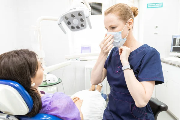 Conceito de Odontologia. Serviços odontológicos profissionais e equipamentos modernos sem dor. O médico consulta e trata a jovem, realiza um exame e elabora um plano de tratamento. — Fotografia de Stock