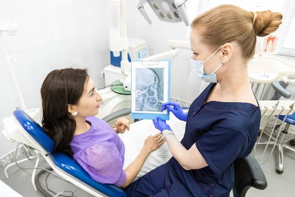 치과 개념입니다. 전문 치과 서비스와 통증없는 현대 장비. 의사는 그 젊은 여자 와상의 하여 치료를 하고, 검사를 하고 치료 계획을 작성 한다 — 스톡 사진
