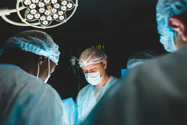 Le chirurgien principal dans la salle d'opération, où le patient l'attend, et il commence l'opération. Véritable hôpital moderne avec équipement authentique. — Photo