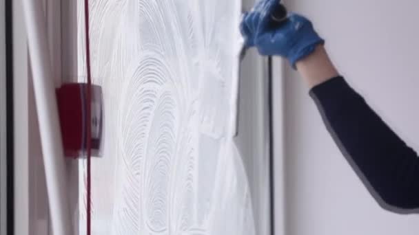 Een professionele glazenwasser zepen en piepen een raam schoon, mannelijke schoonmaakster. — Stockvideo