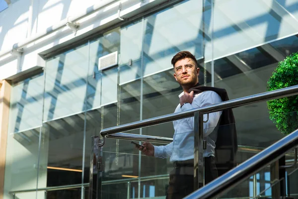 Retrato de un hombre de negocios en traje están de pie en el fondo de las oficinas de vidrio. — Foto de Stock