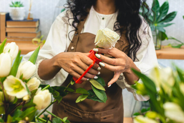 Привлекательная молодая женщина-флористка работает в цветочном магазине.