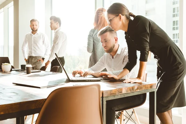 Ett team av unga affärsmän som arbetar och kommunicerar tillsammans på ett kontor. Företagsöverlåtelse och chef på möte. — Stockfoto