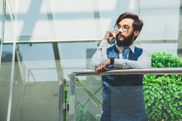 Retrato de un hombre de negocios en traje están de pie en el fondo de las oficinas de vidrio. — Foto de Stock