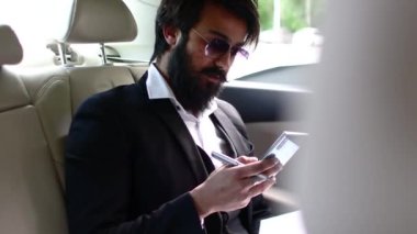 Arabadaki şık Hintli işadamı akıllı telefon kullanıyor. İş çağrıları ve birlikte hareket edebilirlik